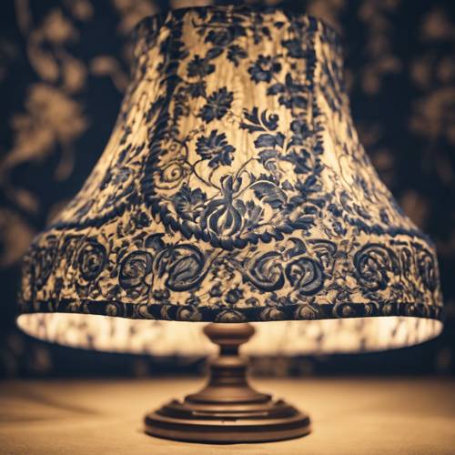 Un primer plano de una pantalla de lámpara de damasco azul marino que proyecta una luz suave en la habitación.