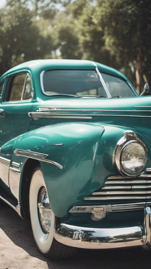 A vintage automobile polished in a cool teal color.