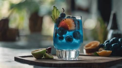 Cóctel con frutas tropicales azules servido en un vaso elegante