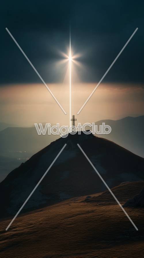 Cruz iluminada pelo sol no pico de uma montanha