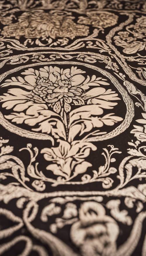 An antique damask tablecloth with an ornate floral pattern spread over a wooden dining table.