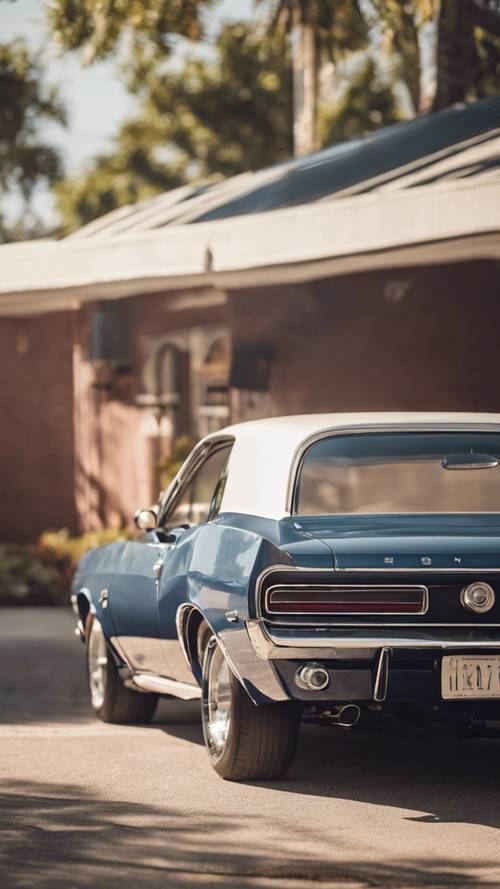 Un profil latéral d&#39;une muscle car vintage bleu marine scintillant sous le chaud soleil de midi.