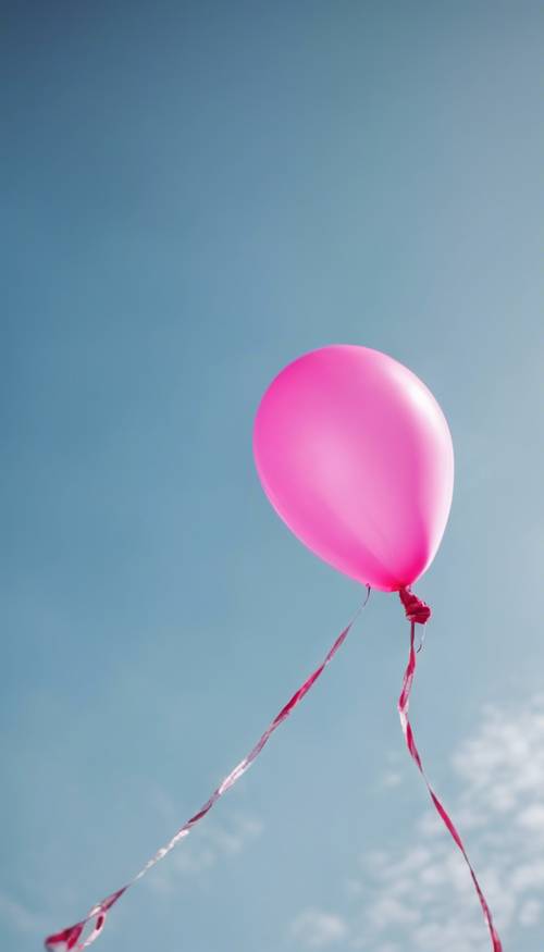 Pływający, gorący, różowy balon w kształcie gwiazdy świecący na tle czystego, błękitnego nieba.