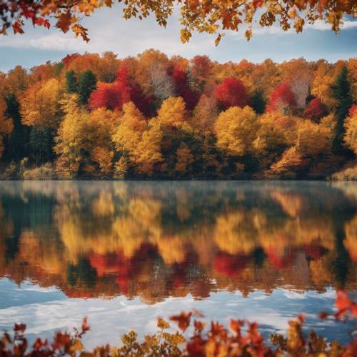 A vibrant blanket of fall foliage reflecting on the glassy surface of a lake.