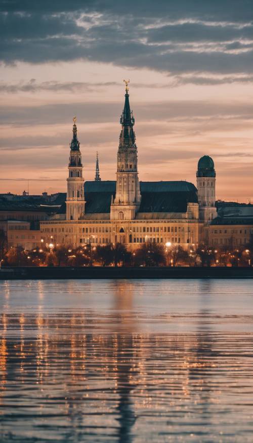 Spokojny obraz Wiednia o zmierzchu, ze światłami budynków miejskich odbijającymi się w błękitnym Dunaju.