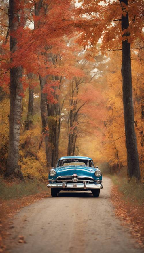 A classic 1950s car parked on a country road lined with vibrant fall-colored trees.