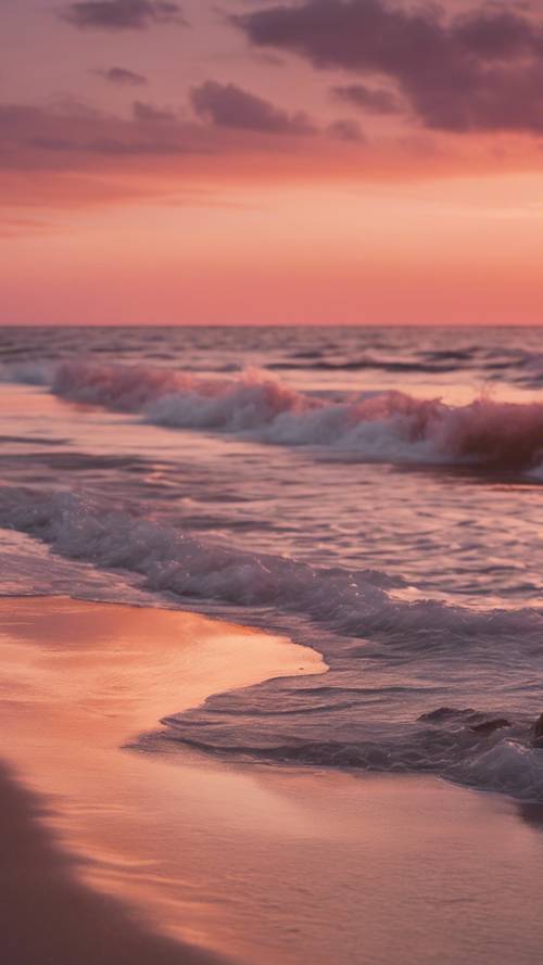 A calming beach scene at sunset, with pink and orange hues reflected on the calm ocean waves.