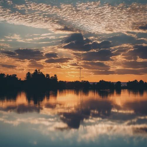 Un lago argentato increspato che riflette le sfumature del sole al tramonto