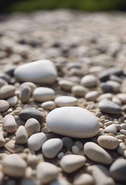 A couple of white pebble stones lying on top of a Zen garden.