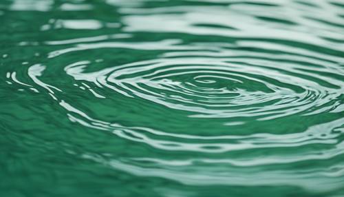 صورة مجردة لتموجات المياه الخضراء المريمية التي يزعجها بلطف حجر أملس.