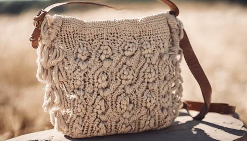 Bolso boho de crochet beige intrincadamente elaborado atrapado en la luz del día de verano