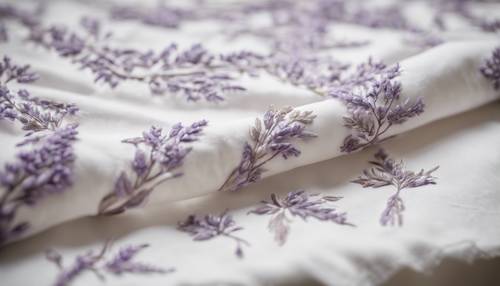 Uroczy prowansalski obrus z ręcznie wyszytym haftem w kolorze lawendy na białej lnianej tkaninie.
