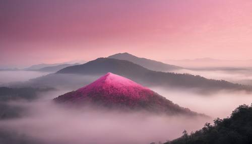 Uma solitária montanha rosa envolta em névoa ao amanhecer.