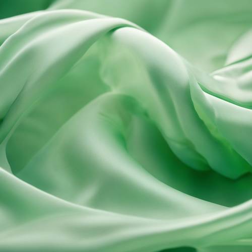 柔軟的淺綠色絲綢的抽象波浪在微風中蕩漾。