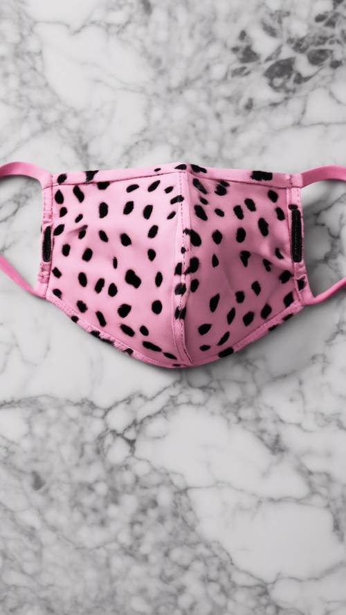A pink cheetah print face mask, placed on a white marble surface.