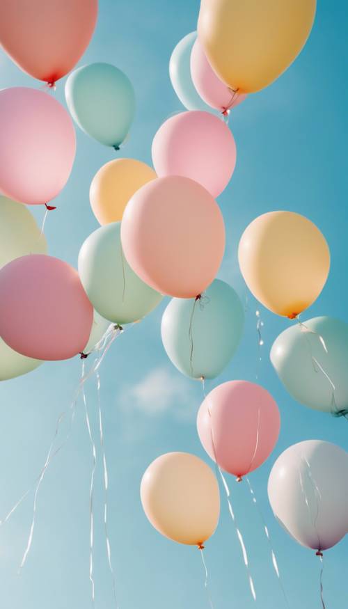 Parlak ve güneşli bir günde açık gökyüzünde süzülen bir grup pastel renkli balon.