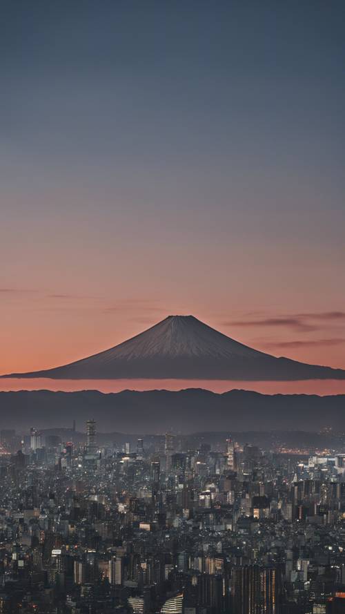 Veduta dello skyline di Tokyo al tramonto con la sagoma del Monte Fuji sullo sfondo.