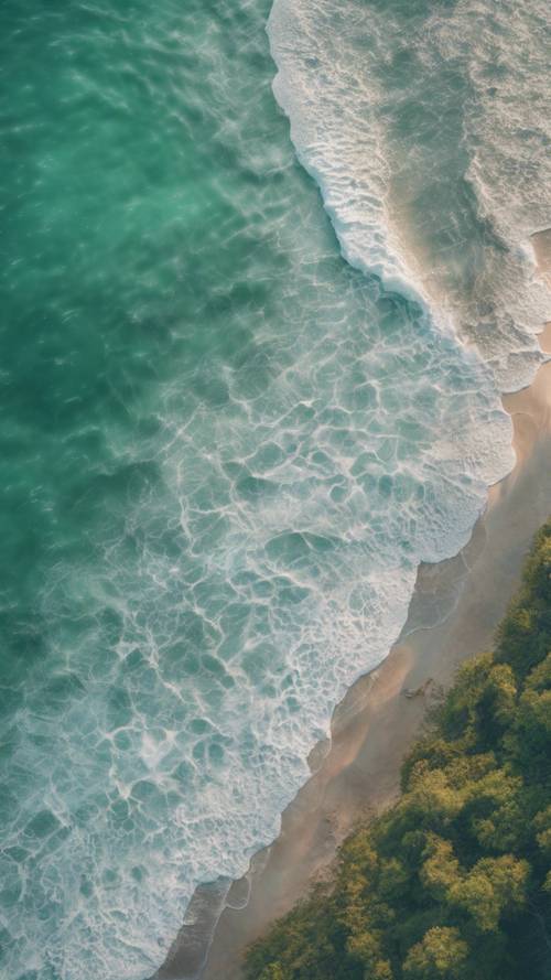 Eine Aufnahme aus der Vogelperspektive eines pastellgrünen Meeres an einem friedlichen frühen Morgen.