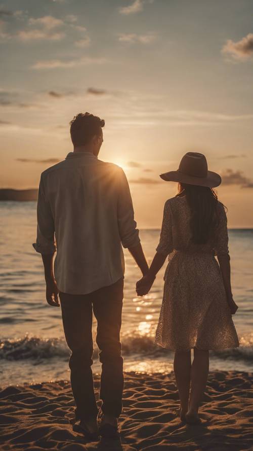 Para trzymająca się za ręce, stojąca na tle zachodzącego słońca.