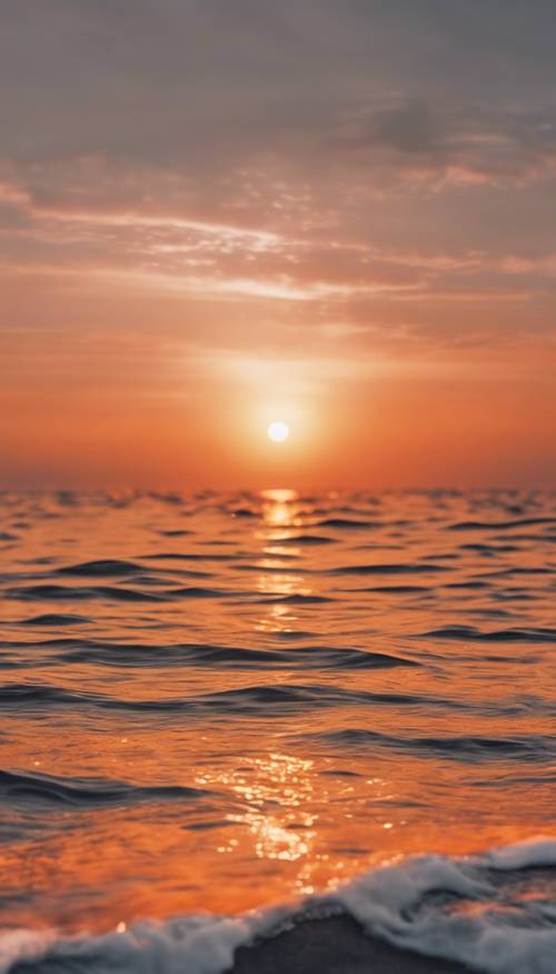 พระอาทิตย์ตกสีส้มและสีขาวที่สดใสเหนือมหาสมุทรอันเงียบสงบ