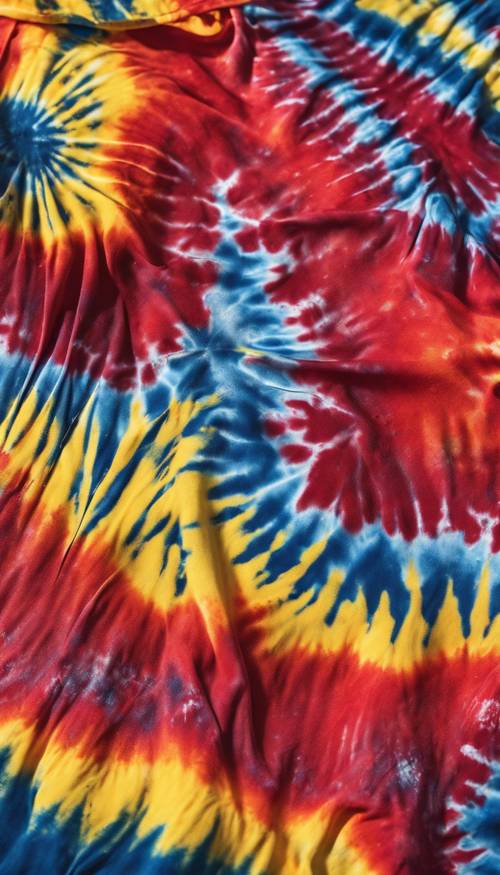 An up-close view of a vibrant tie-dye t-shirt blending colors of red, blue, and sunny yellow.