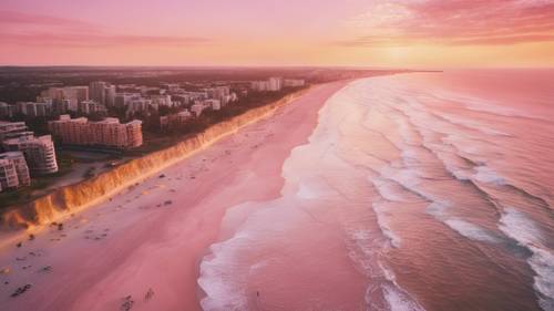 منظر جوي لشاطئ وردي وذهبي عند غروب الشمس.