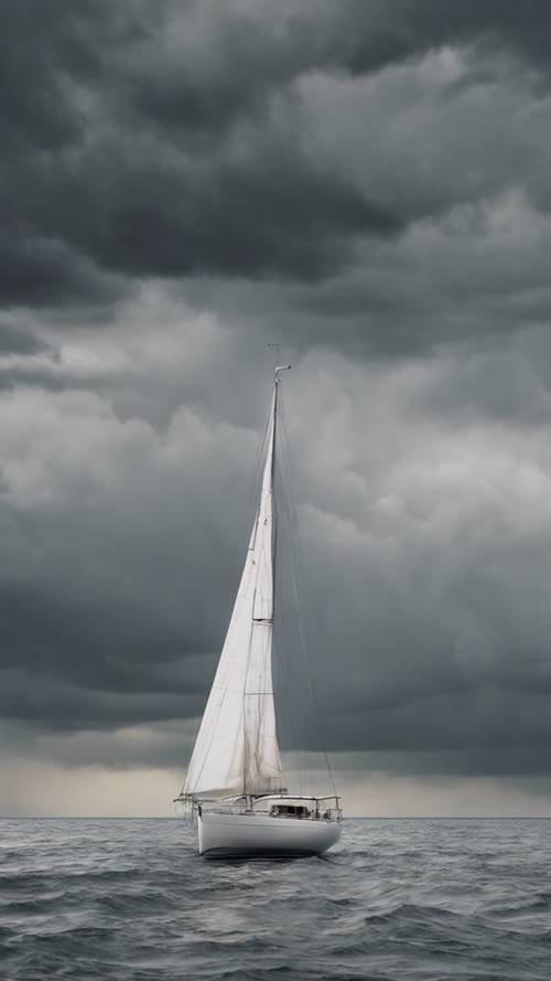 Um veleiro cinza e branco navegando sozinho no meio do oceano sob um céu cinzento e tempestuoso.