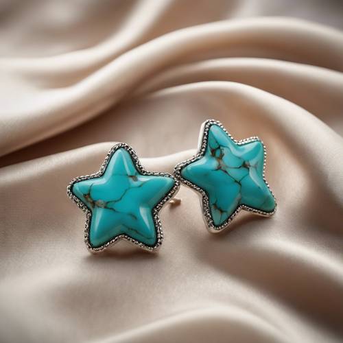A pair of glossy star-shaped earrings made from turquoise, resting on a silk cushion.