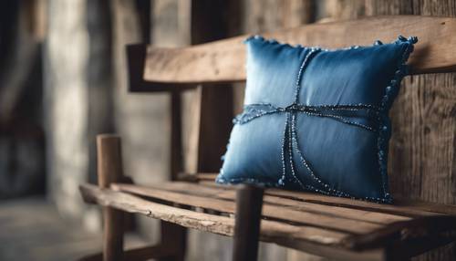 Un cojín de seda azul apoyado sobre una silla rústica de madera.