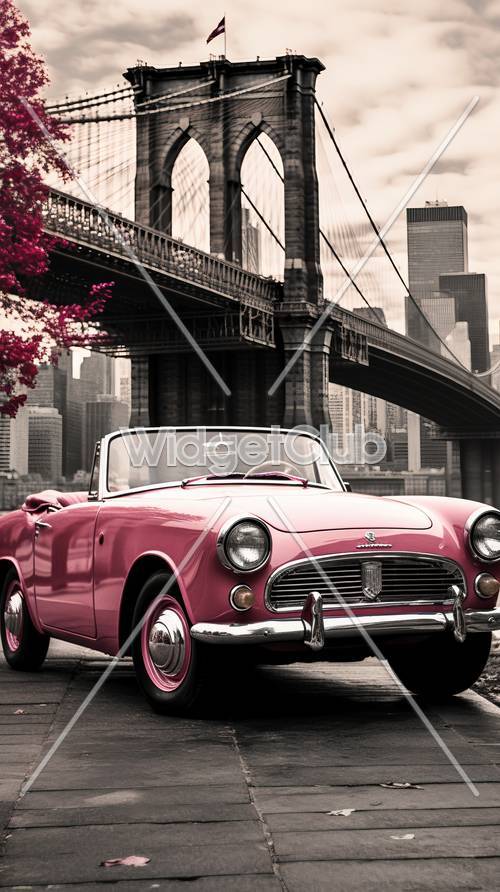 背景に橋が見える街中を走るピンクのクラシックカー