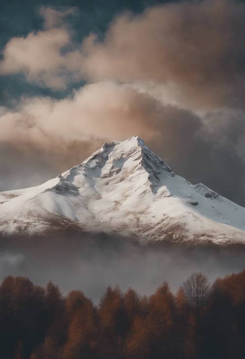 Alışılmadık kahverengi bulutlarla dolu bir gökyüzüne doğru uzanan karlı bir dağ zirvesi.