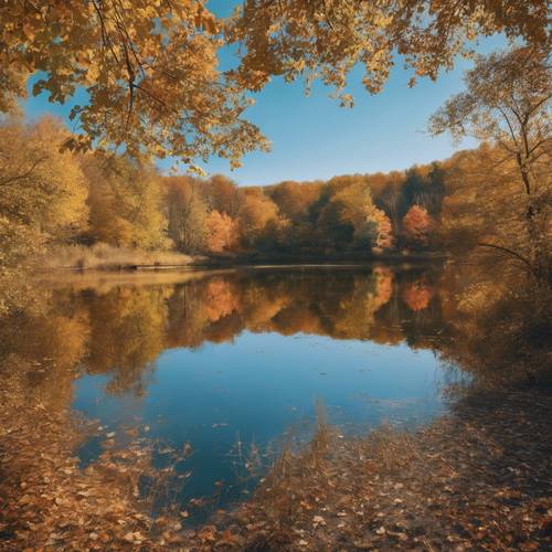 A serene lake mirroring a surrounding deciduous forest adorned in a palette of autumn colors under a clear blue sky.