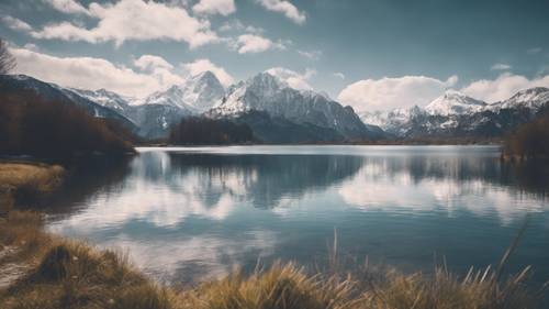 A calming, serene image of an alpine lake surrounded by snow-capped mountains, with 'The journey of a thousand miles begins with a single step' faintly visible in the clouds above.