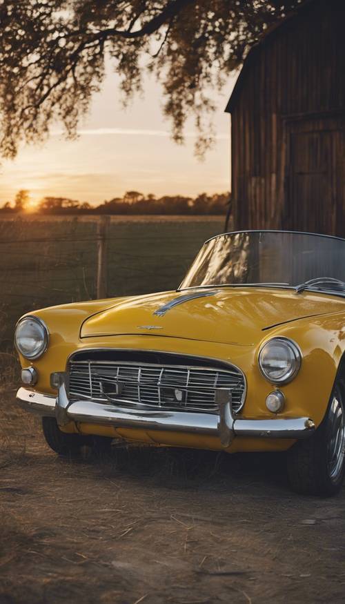 A vintage yellow roadster parked in front of a rustic barn at dusk. Tapet [6ff627d0f43c4f2a82e4]
