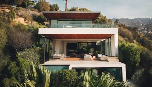 A modern home nestled in the Hollywood Hills with views over Los Angeles surrounded by lush greenery.