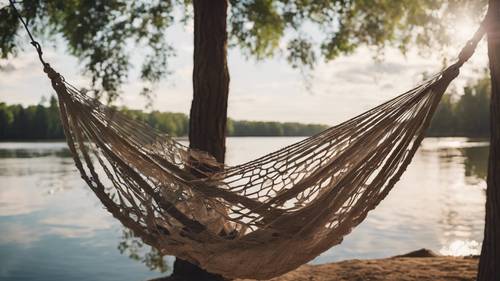 從水邊兩棵樹之間懸掛的預科生風格的吊床上可以欣賞到質樸、寧靜的夏季湖景。