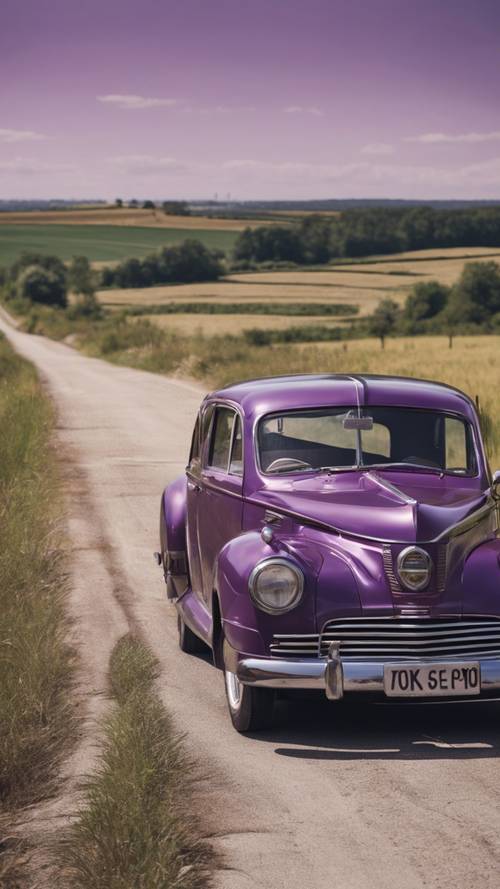 Um carro roxo antiquado dirigindo por uma estrada deserta no meio do dia.