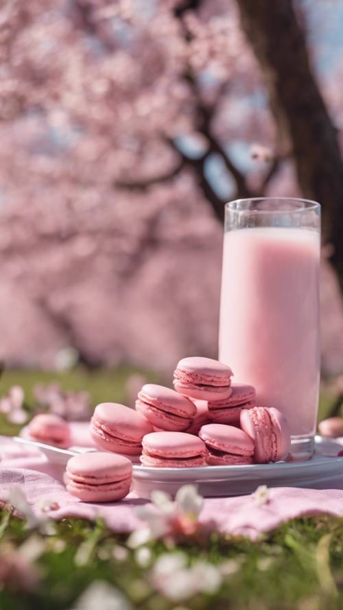 Un pique-nique sous les cerisiers en fleurs avec des macarons roses et du lait à la fraise.
