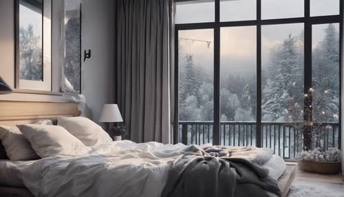 A bedroom with cozy gray and white decor and a beautiful view of falling snow outside.