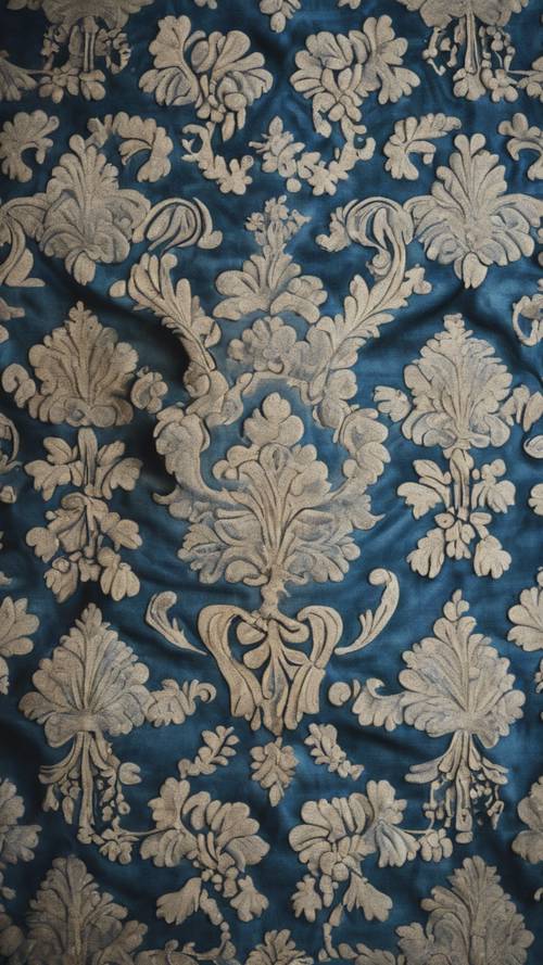Un primer plano de un patrón de damasco azul en tapicería vintage.