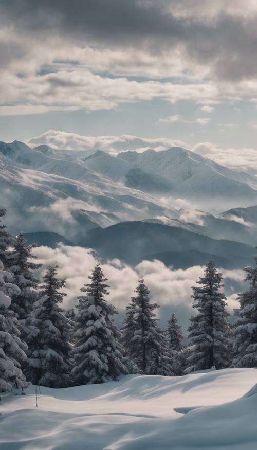 Uma vista pitoresca de uma cadeia de montanhas cobertas de neve aparecendo através de uma cortina de nuvens espessas e fofas de inverno.