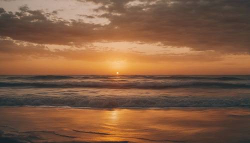 Uma vista deslumbrante do pôr do sol no oceano com tons ombré mudando gradualmente de laranja escuro para amarelo claro.