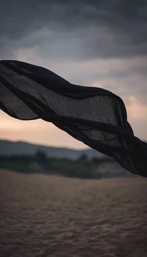 Un grande pezzo di tessuto di lino nero che vola nella brezza serale.