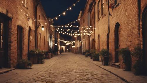 Uma rua em uma cidade velha ao anoitecer, edifícios antigos de tijolos marrons alinhados na calçada, com luzes cintilantes penduradas.