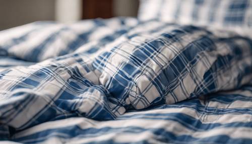 Un primer plano de un pijama a cuadros azul y blanco tumbado en una cama, iluminado suavemente por la luz de la mañana.