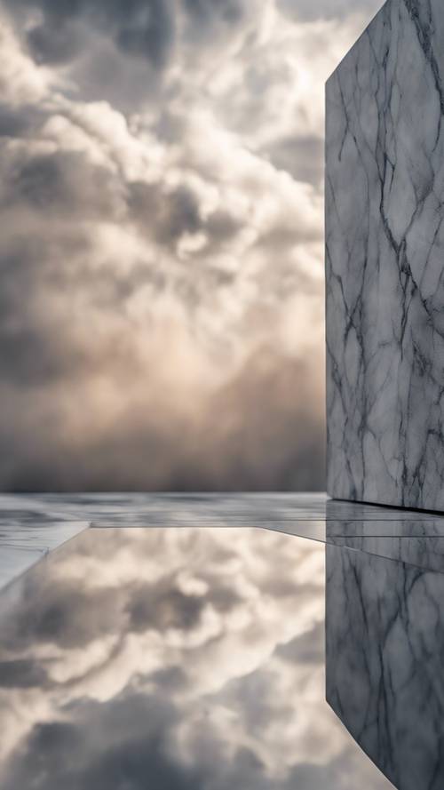 A reflection of the cloudy sky on a smooth, polished surface of gray marble.