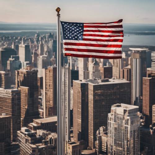 繁华的城市景观上方，旗杆上飘扬着一面巨大的美国国旗。
