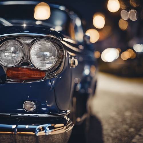 A textured navy blue classic car parked by the roadside with city lights behind.