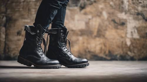 Un par de botas de cuero negro, atadas y desgastadas, colocadas desafiantes contra una pared sucia.