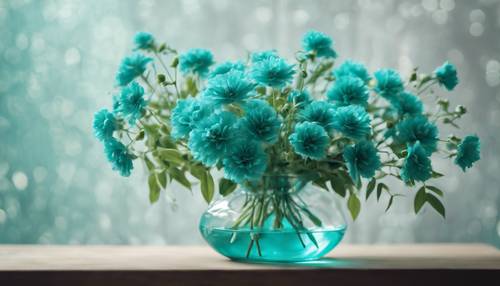 Turkusowe kwiaty ułożone elegancko w przezroczystym szklanym wazonie.